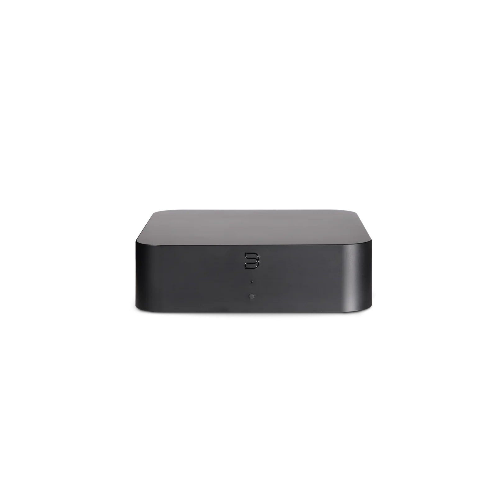 Compact black Bluesound HUB network audio accessory beside music media