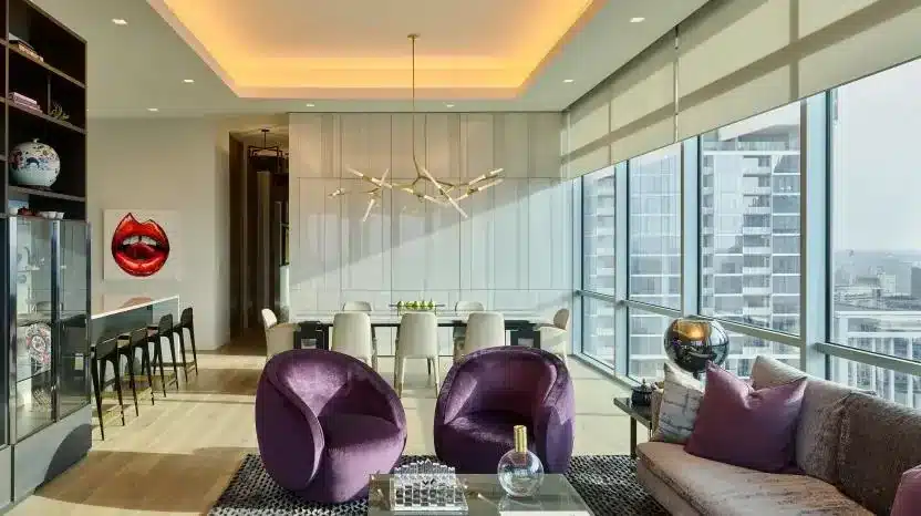 Modern living and dining space with coordinated lighting and motorized shades