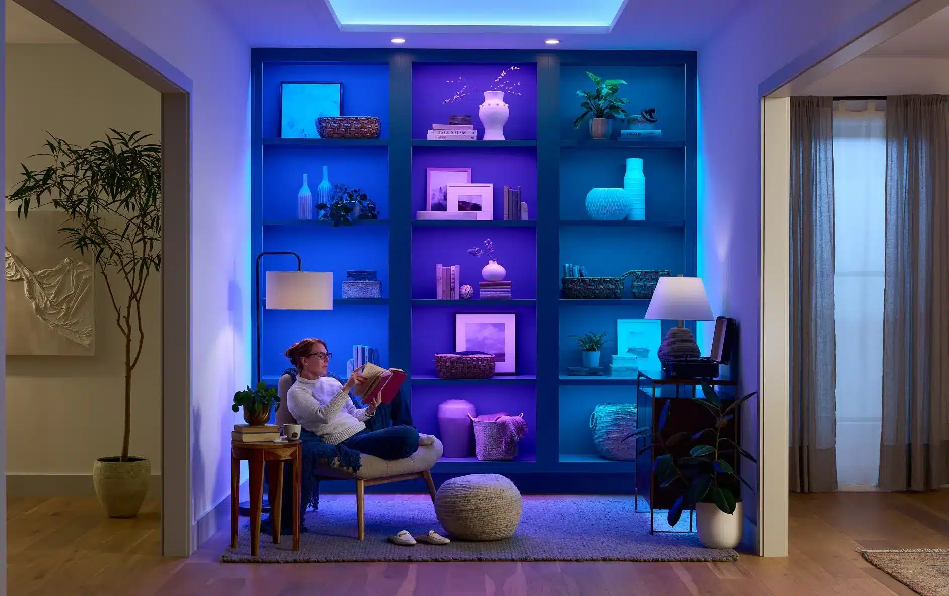 Built-in bookshelves illuminated by colorful Lutron Lumaris tape lighting