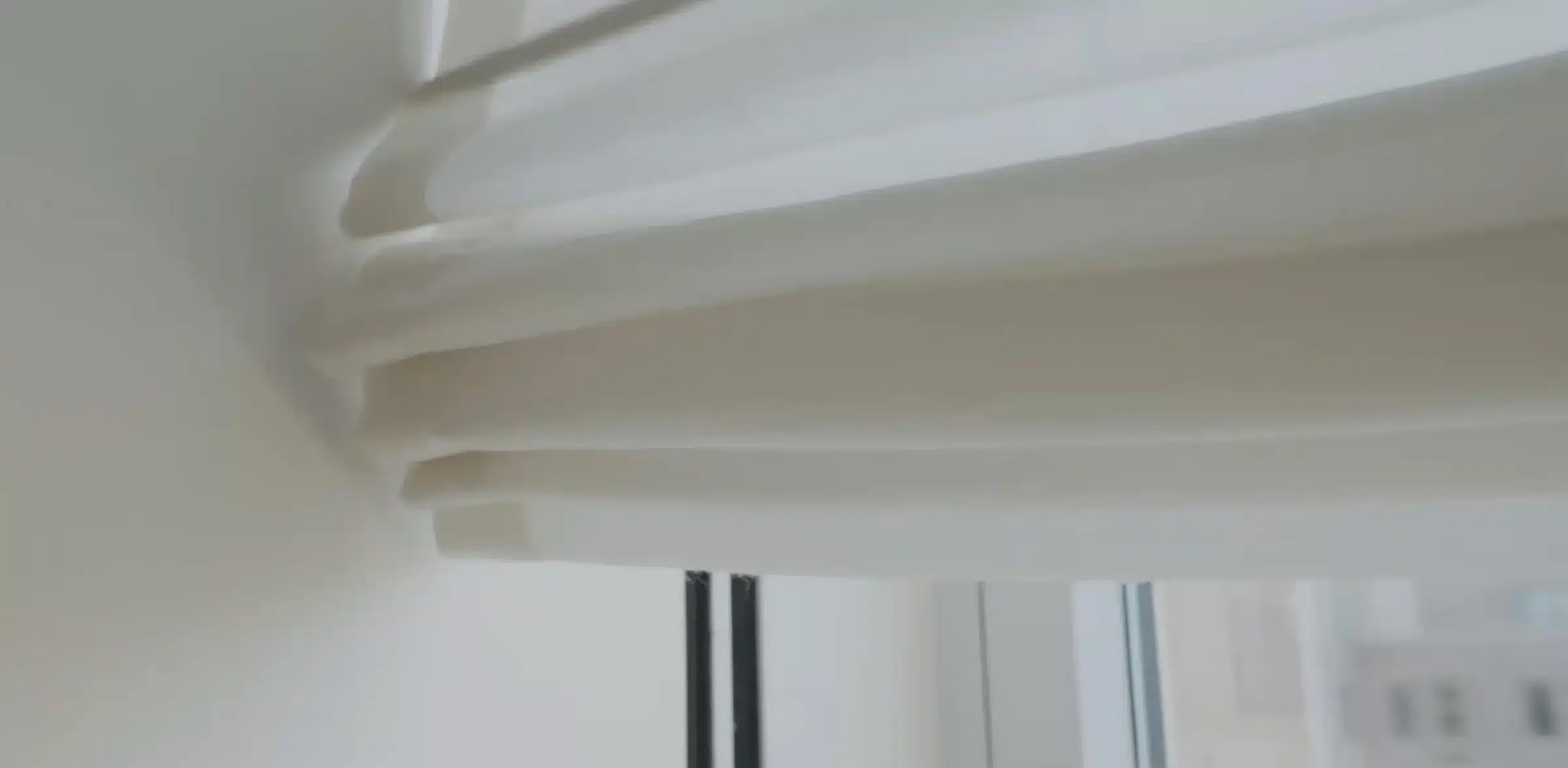 Close-up of a concealed Lutron Triathlon roller shade at a window
