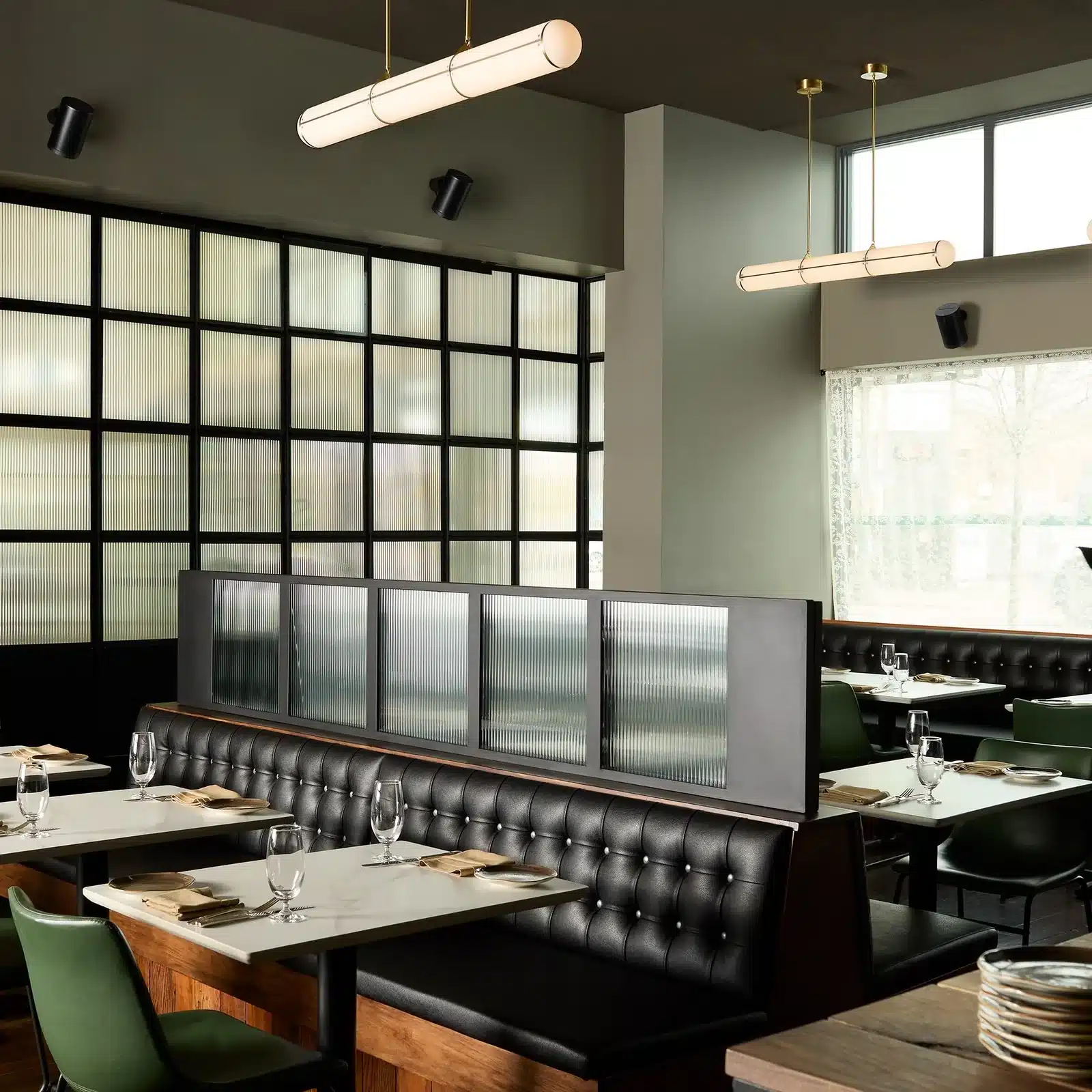 Sonos Era 100 Pro speakers mounted throughout a contemporary dining space